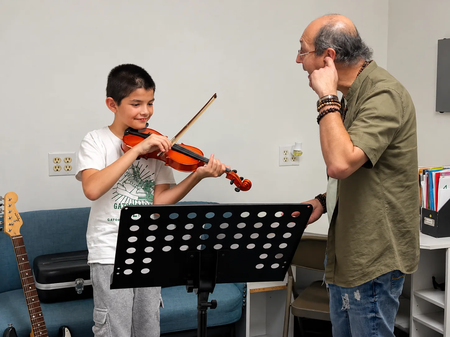Violin student working with his teacher