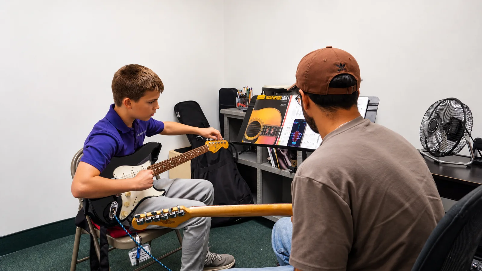 Guitar student learning with a teacher