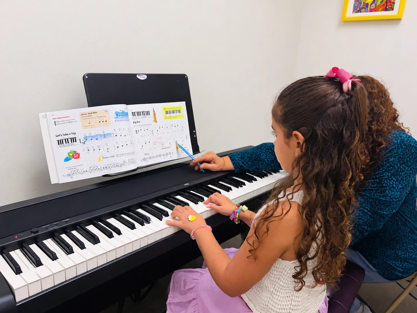 Teacher helping a young student at the piano
